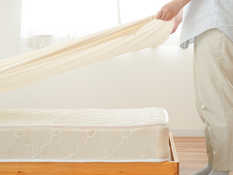 厚みのあるマットレスにノビックを装着する様子