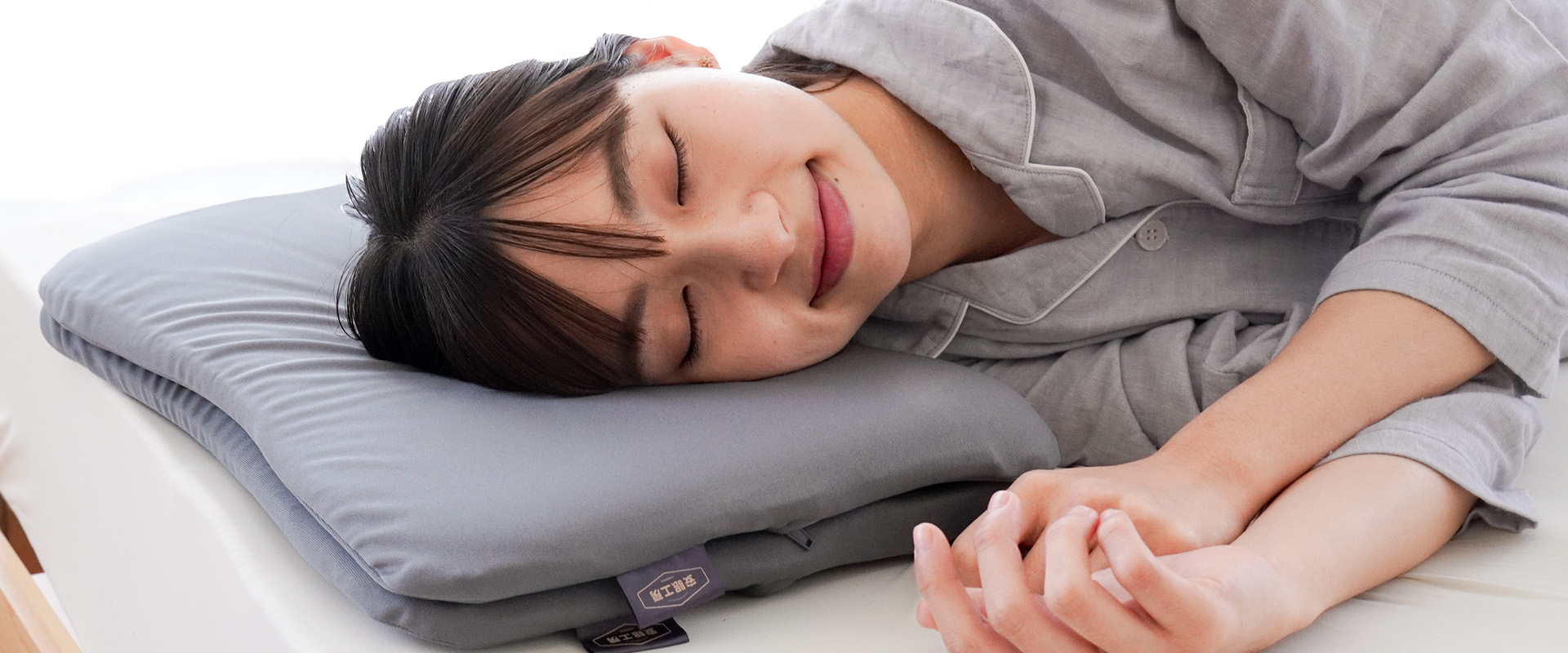 西川 低反発まくら ぺらーり を使って横になる女性